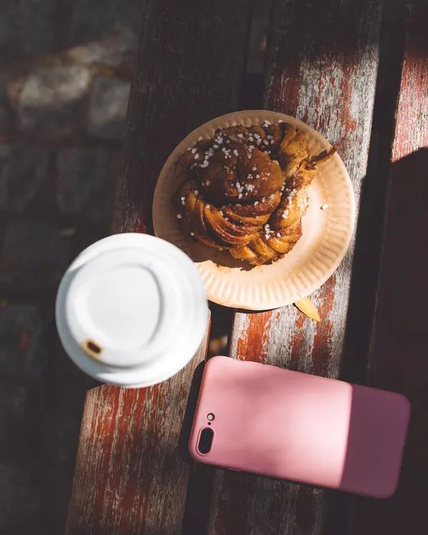 A cup of coffee and a bun